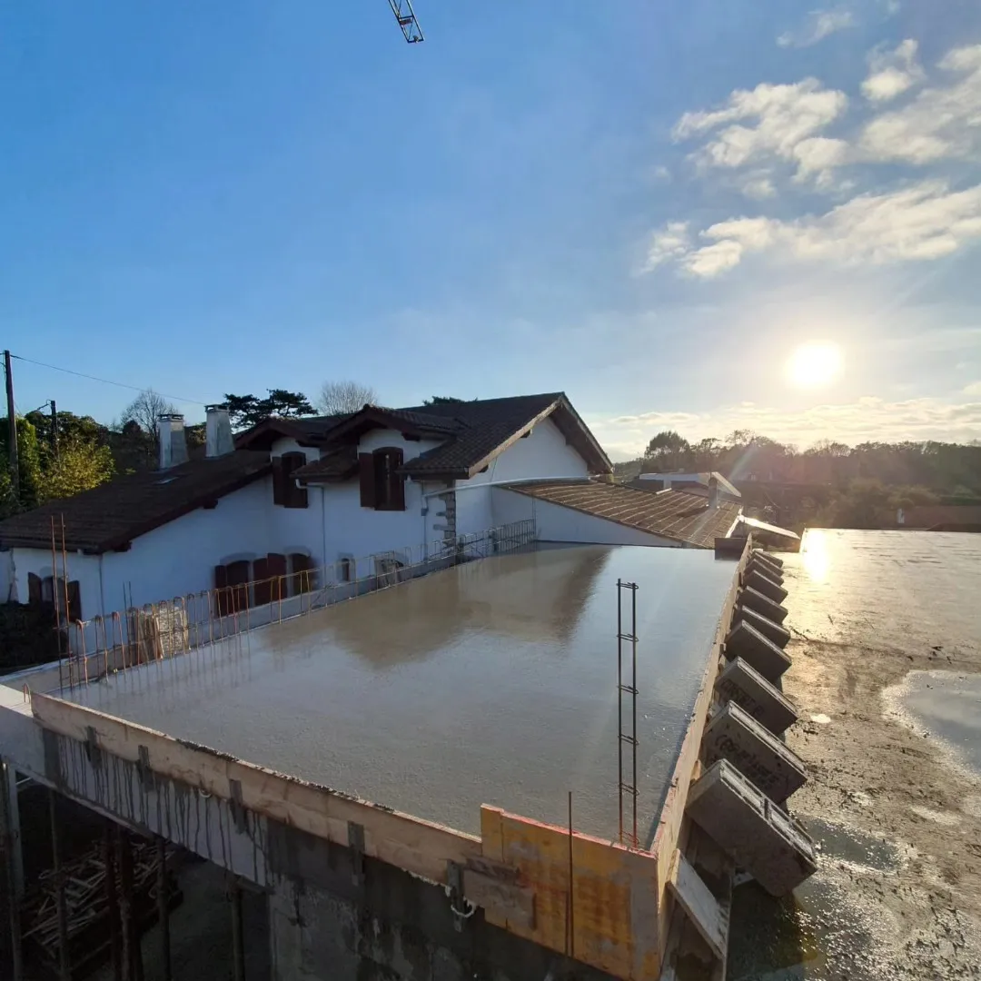 Dalle béton coulée sur un chantier Hemengoa au coucher du soleil