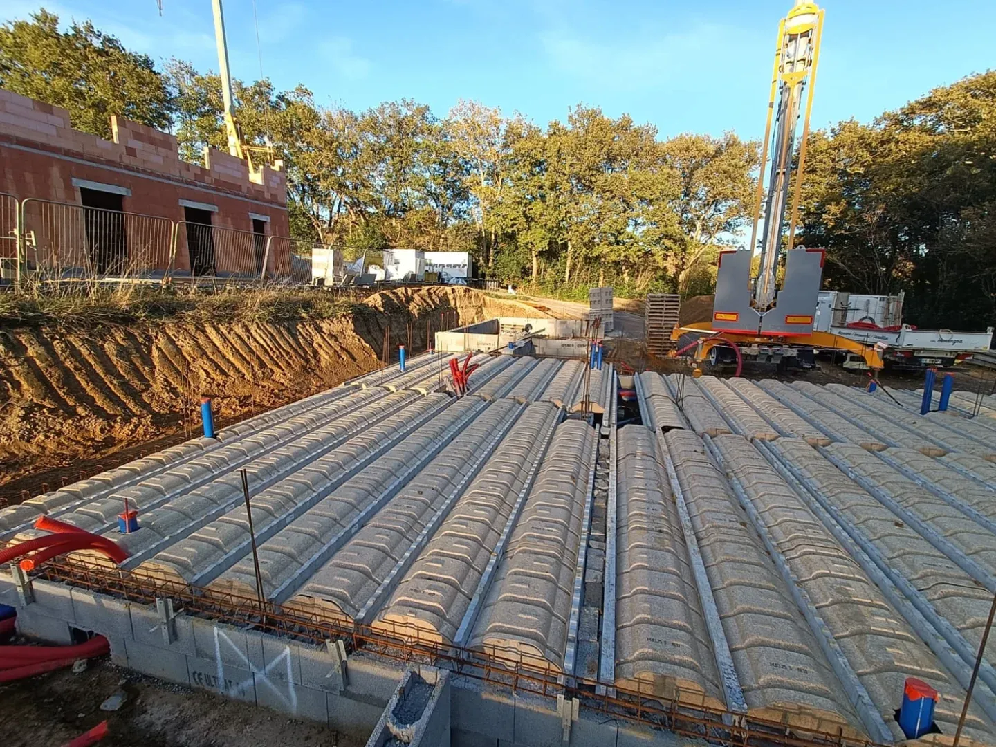 Plancher à poutrelles et hourdis en cours de pose, armatures en attente de coulage