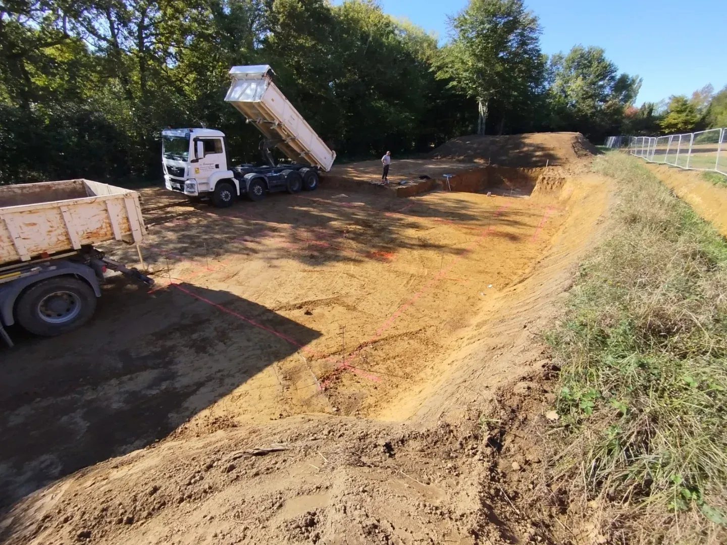 Camion benne évacuant les terres du terrassement, piste d’accès ouverte jusqu’à la plateforme